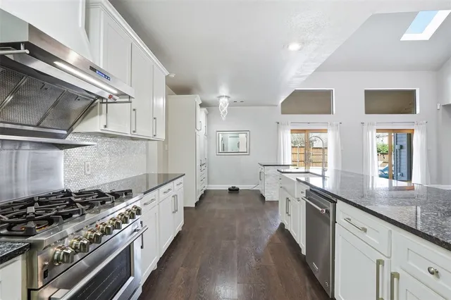 a large white kitchen with stainless steel appliances