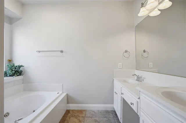 a bathroom with a tub sink and mirror
