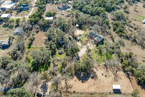 an aerial view of residential house with yard and outdoor seating
