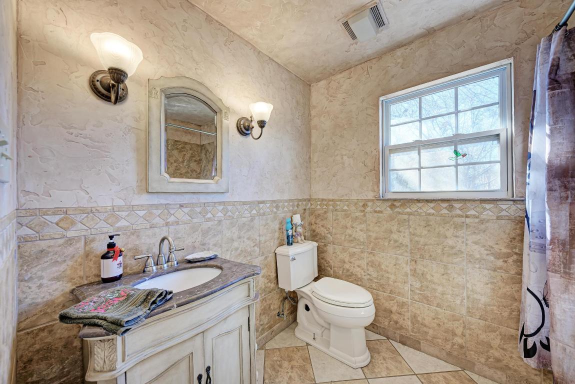 321 Navajo Trail Georgetown, TX 78633 - Photo 18 of 40 a bathroom with a granite countertop sink and a toilet
