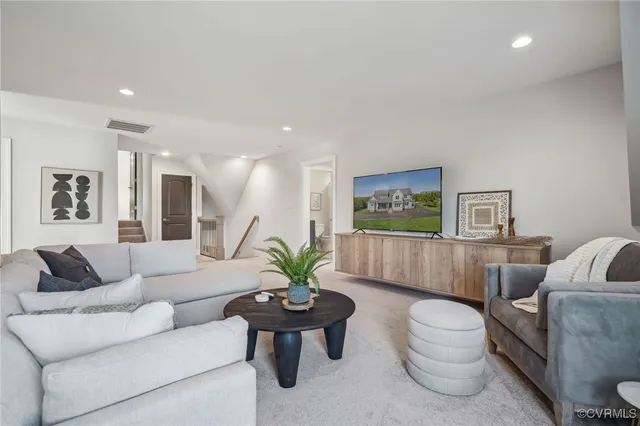 a living room with furniture and a painting on the wall