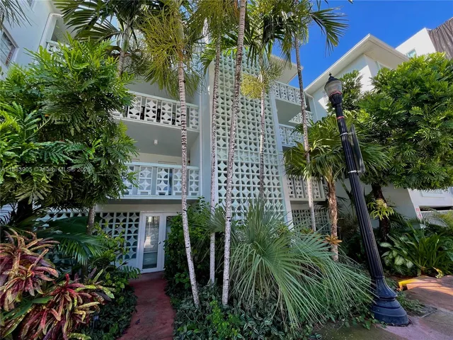 a view of building with yard and potted plants