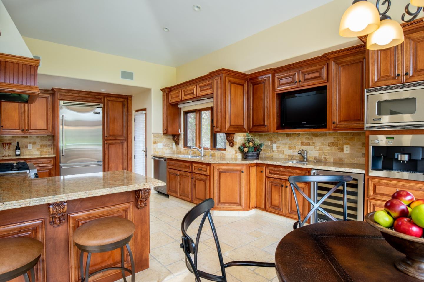 1060 Rodeo Road Pebble Beach, CA 93953 - Photo 10 of 30 a kitchen with stainless steel appliances granite countertop a sink a stove a refrigerator cabinets and chairs