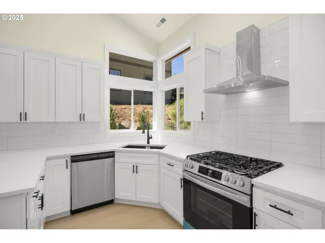 a kitchen with stainless steel appliances a sink stove and cabinets