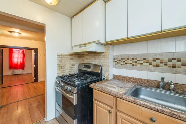 a kitchen with granite countertop a sink a stove and cabinets