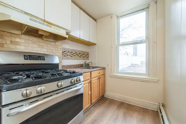 a kitchen with a stove and wooden floor