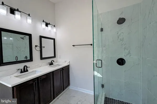 a bathroom with a double vanity sink mirror and shower