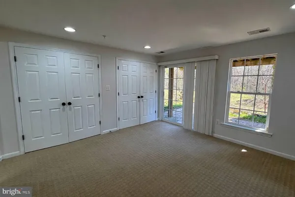 an empty room with windows and closet