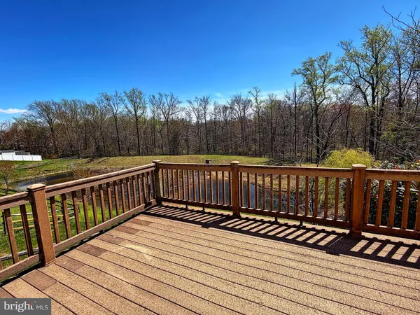 a view of deck with wooden floor and trees in the background