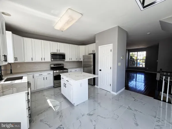 a kitchen with white cabinets and appliances