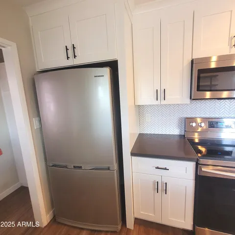 a kitchen with cabinets and a refrigerator