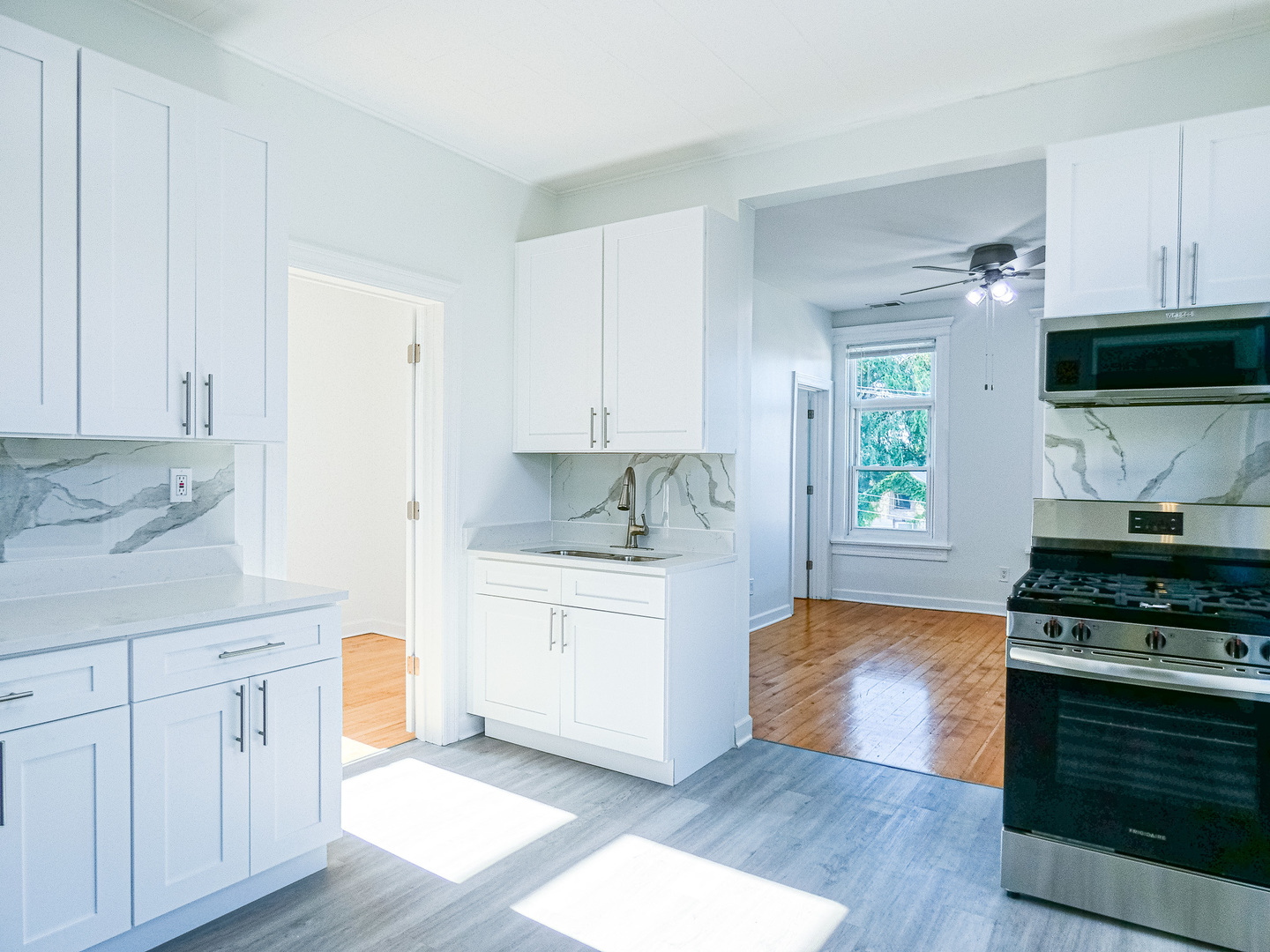 2044 West 19th Street, Unit 3R Chicago, IL 60608 - Photo 2 of 11 a kitchen with granite countertop a stove a sink and a white cabinets