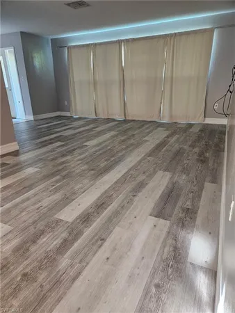 a view of an empty room with wooden floor