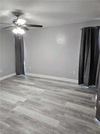 a view of an empty room with a chandelier fan