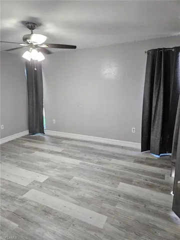 a view of an empty room with a chandelier fan