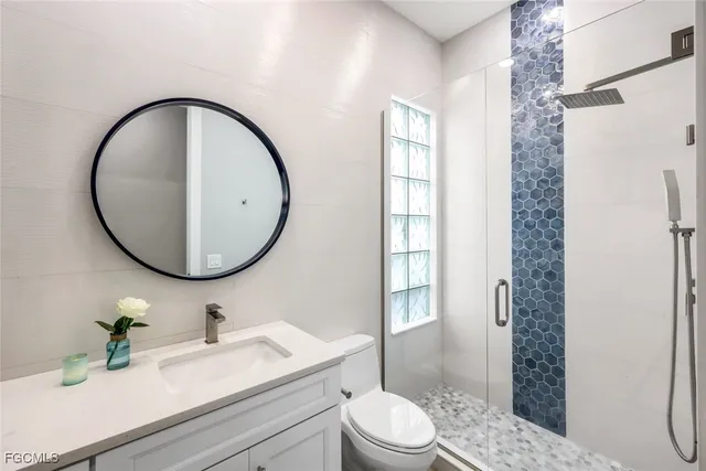 a bathroom with a sink a toilet and a mirror