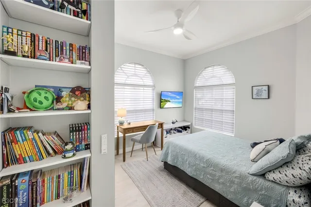 a bedroom with a bed a book shelf and a window