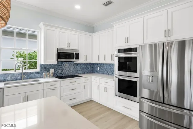 a kitchen with white cabinets stainless steel appliances and sink