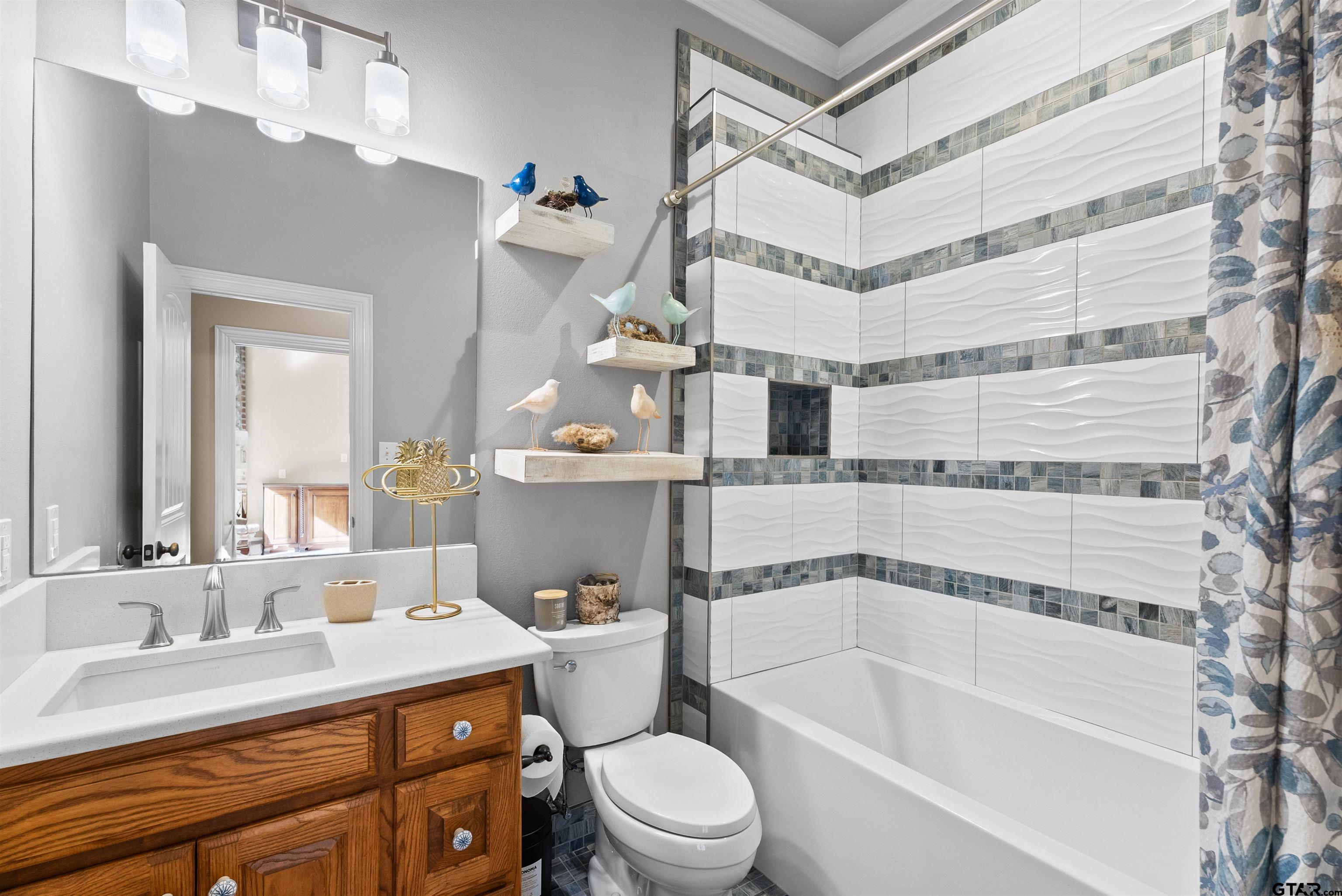 714 Huntwick Lane Tyler, TX 75703 - Photo 11 of 39 a bathroom with a granite countertop sink mirror vanity bathtub and a toilet