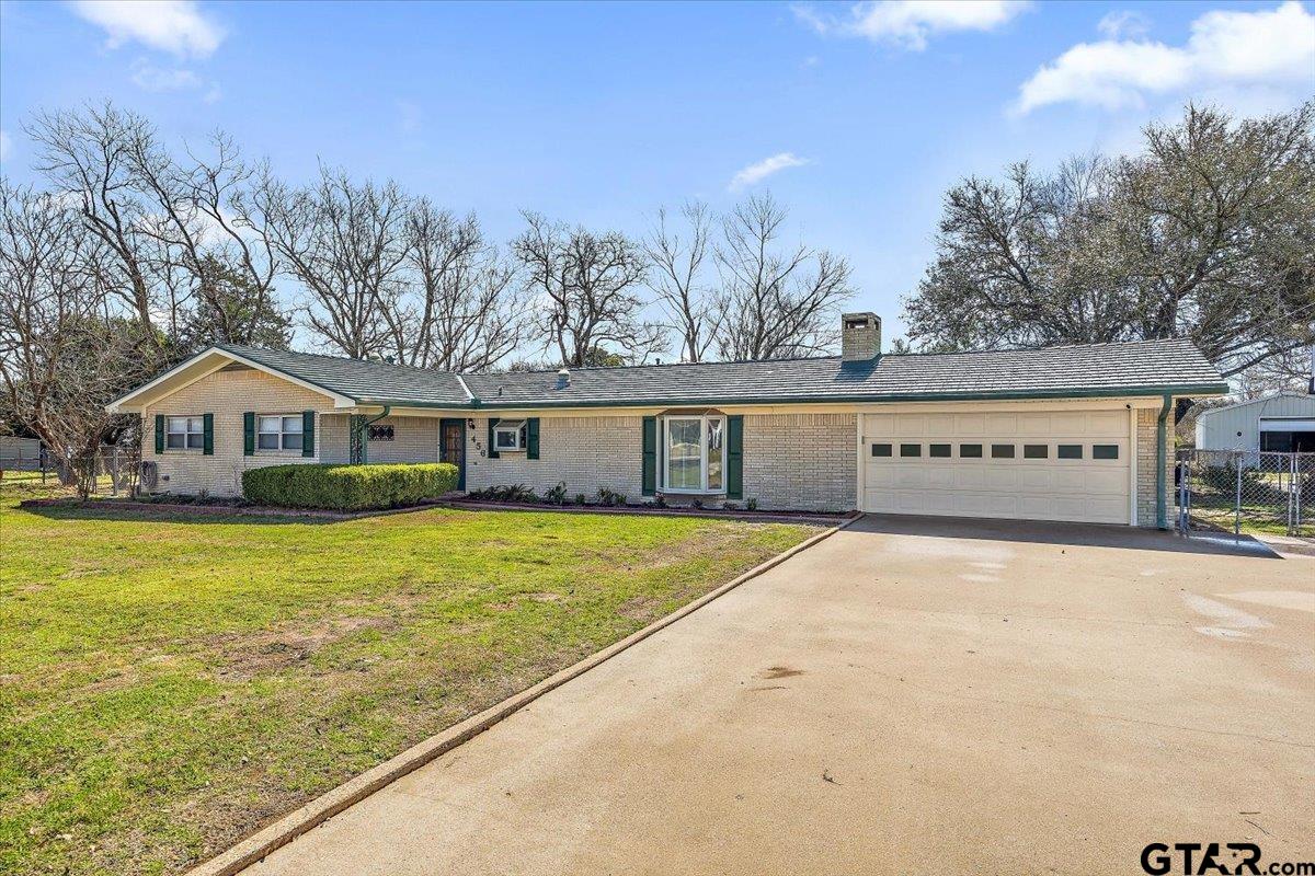 a view of an house with backyard and trees