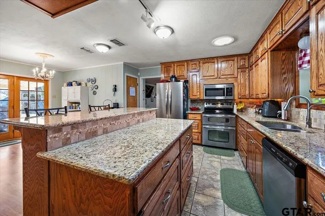 a kitchen with stainless steel appliances granite countertop a sink stove and refrigerator
