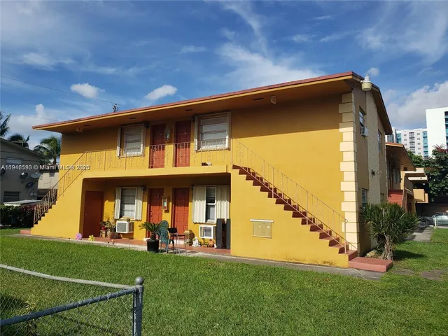 a view of a big house with a big yard and plants