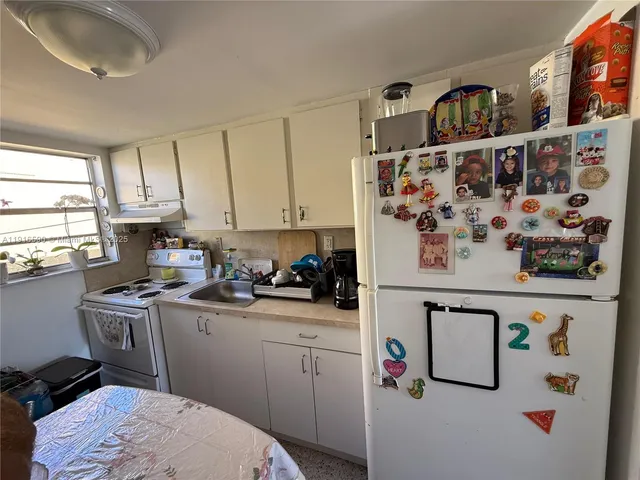 a kitchen with a refrigerator and a sink