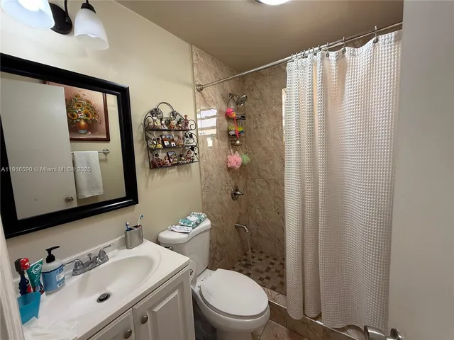 a bathroom with a sink mirror vanity and toilet