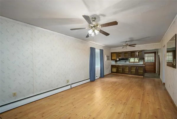 a view of an empty room and kitchen