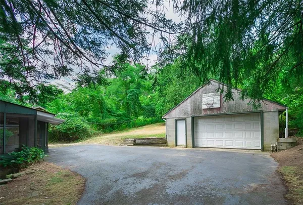 a view of a house with large tree and wooden fence