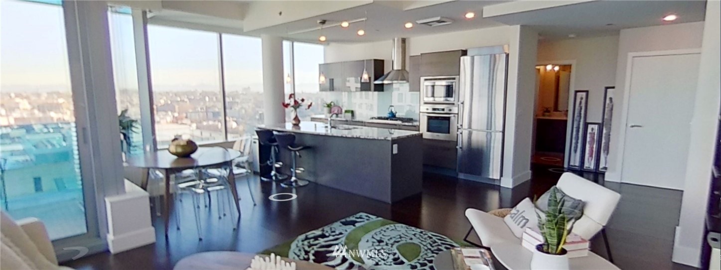 a living room with furniture a large window and stainless steel appliances