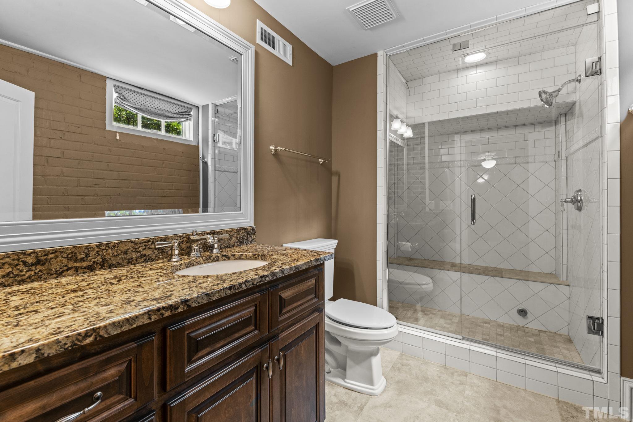 224 Hawthorne Road Raleigh, NC 27605 - Photo 37 of 46 a bathroom with a granite countertop sink a toilet and shower