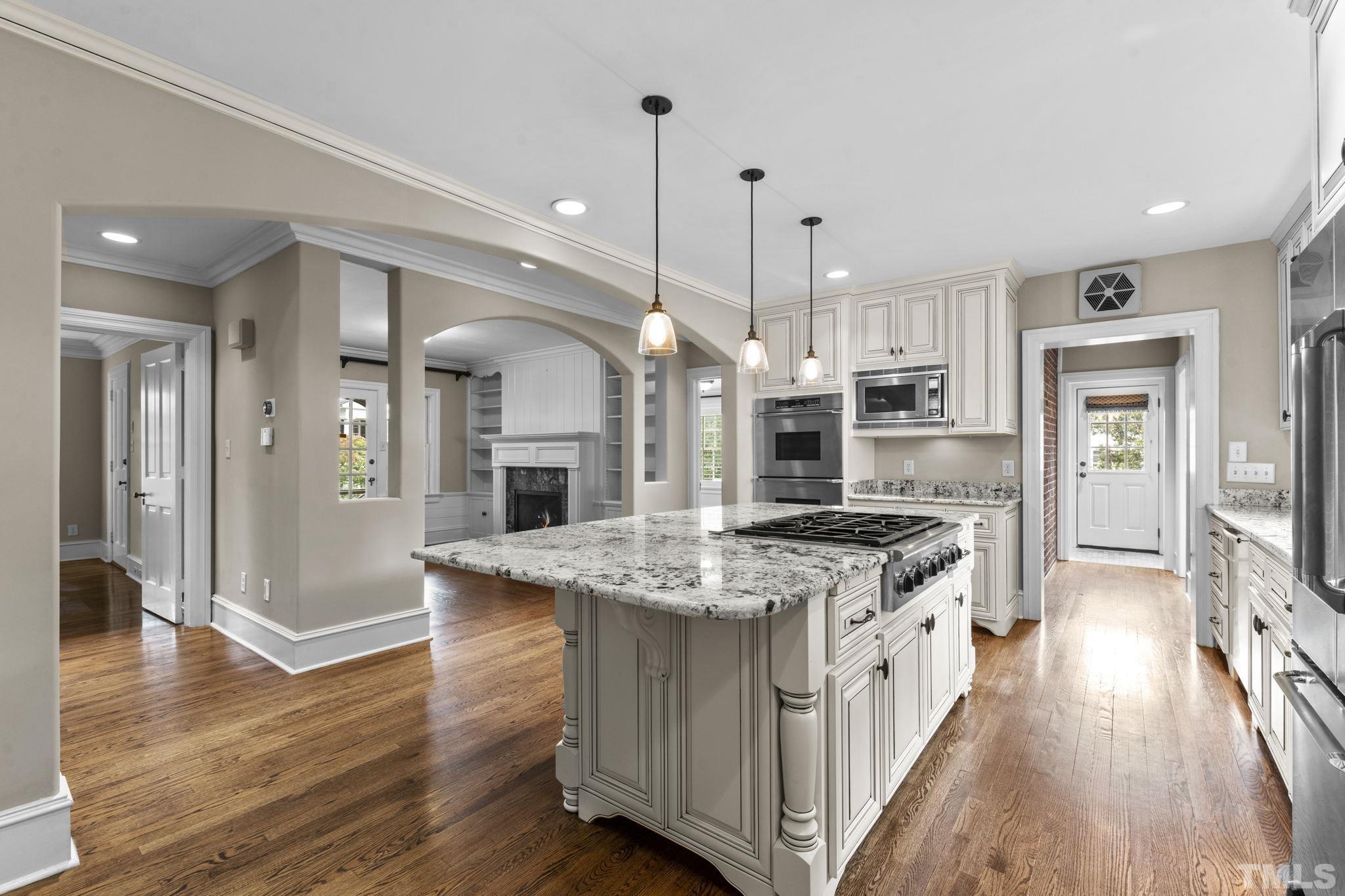 224 Hawthorne Road Raleigh, NC 27605 - Photo 7 of 46 a kitchen with stainless steel appliances granite countertop hardwood floor sink stove and wooden floor