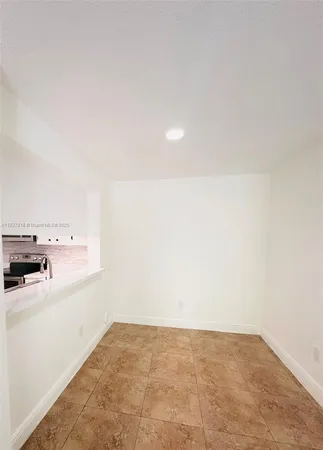 a view of a kitchen with a sink and a refrigerator