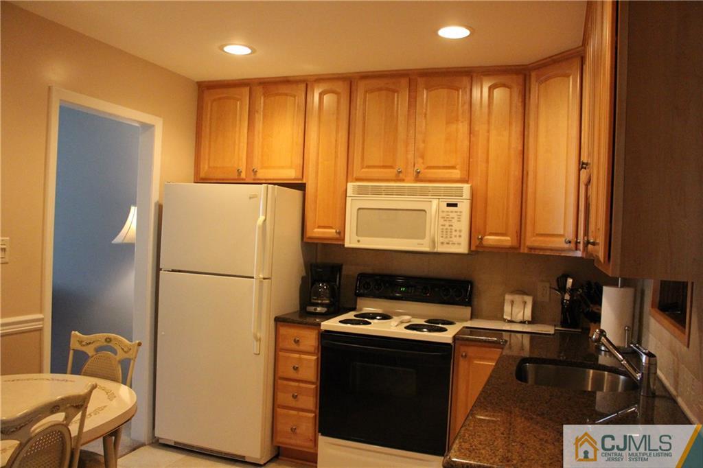 32 Gurley Road Edison, NJ 08817 - Photo 7 of 20 a kitchen with a refrigerator a stove top oven a sink and cabinets