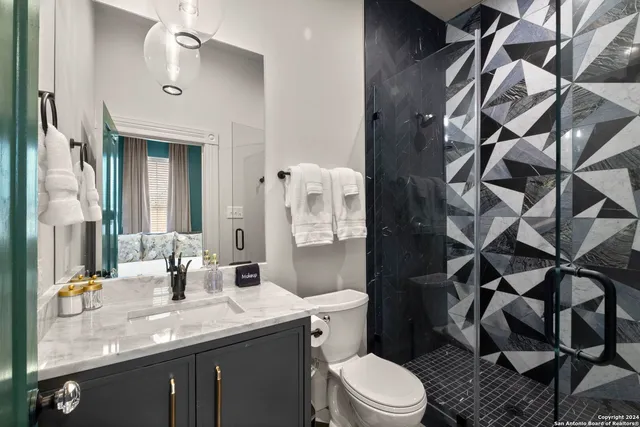 a bathroom with a granite countertop sink toilet and shower