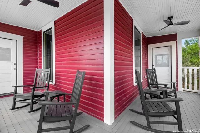 a view of a balcony with chairs and a rug