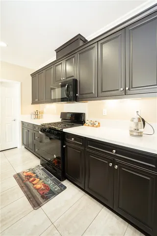 a kitchen with granite countertop a sink cabinets and stainless steel appliances