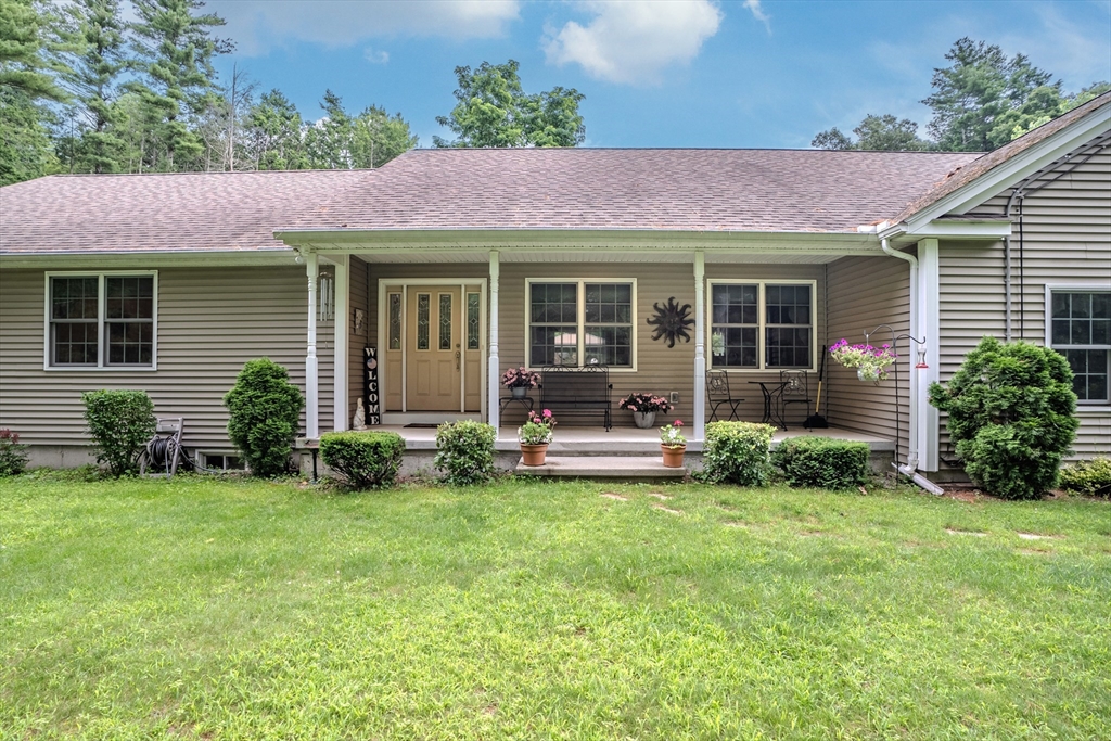 a view of a house with a patio and a yard