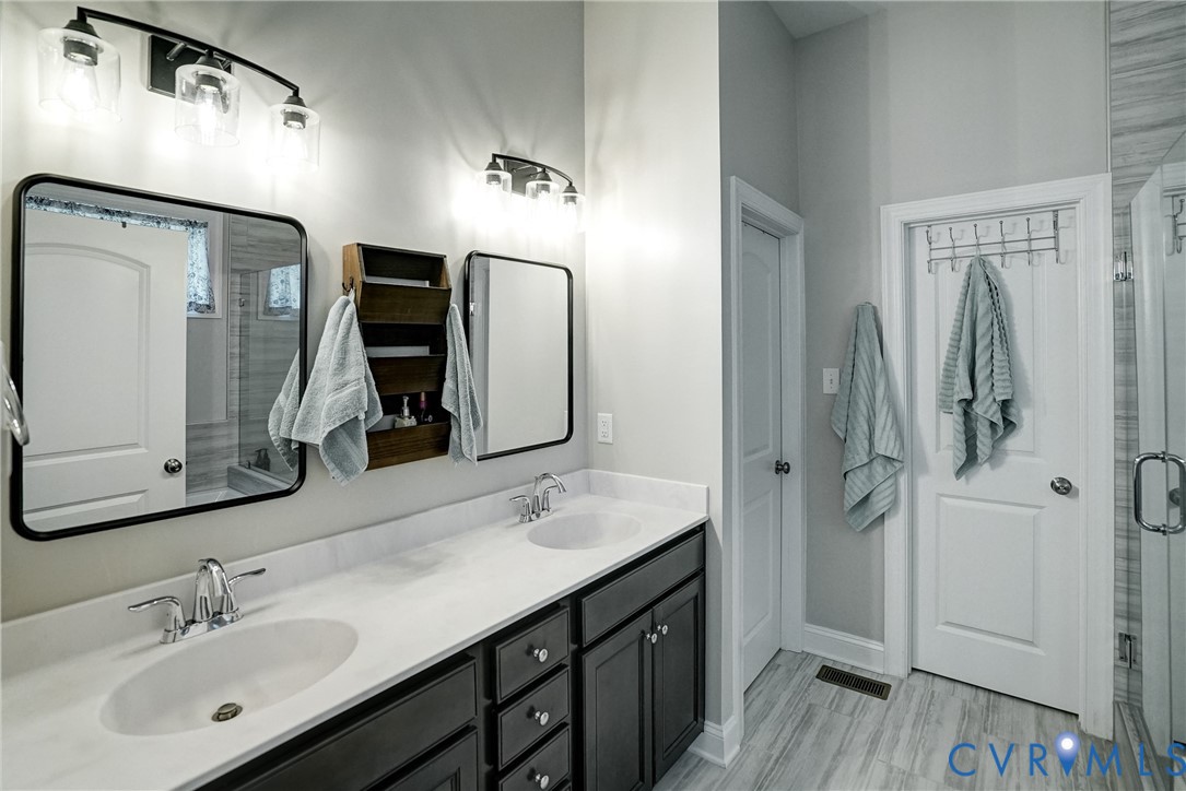 4669 Woburn Road Providence Forge, VA 23140 - Photo 29 of 78 a bathroom with a double vanity sink a vanity and a mirror