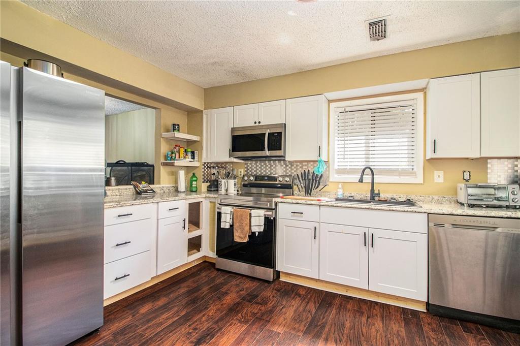 4 Quail Run Decatur, GA 30035 - Photo 6 of 23 a kitchen with sink stainless steel appliances and white cabinets