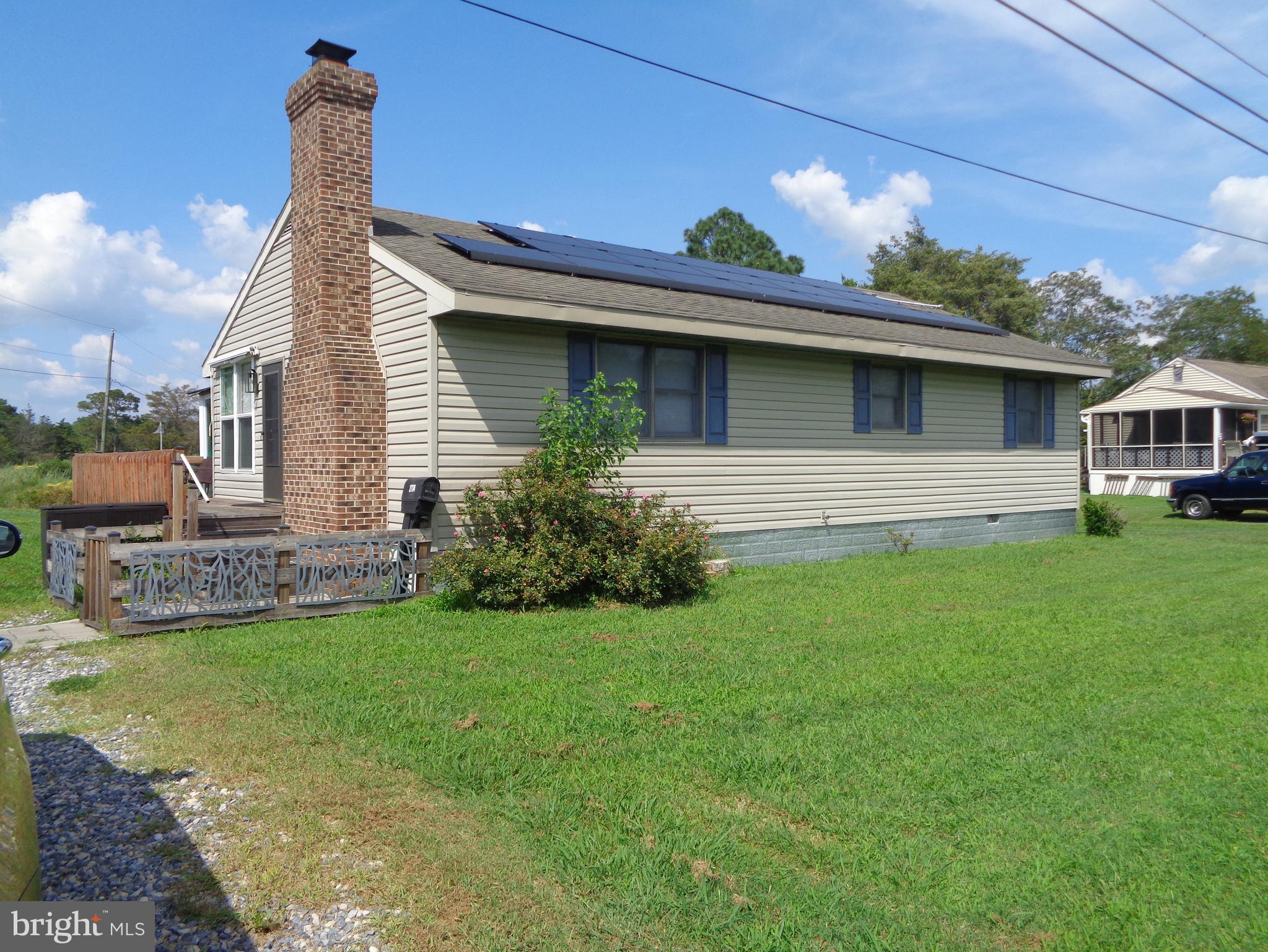 a front view of a house with a garden and plants