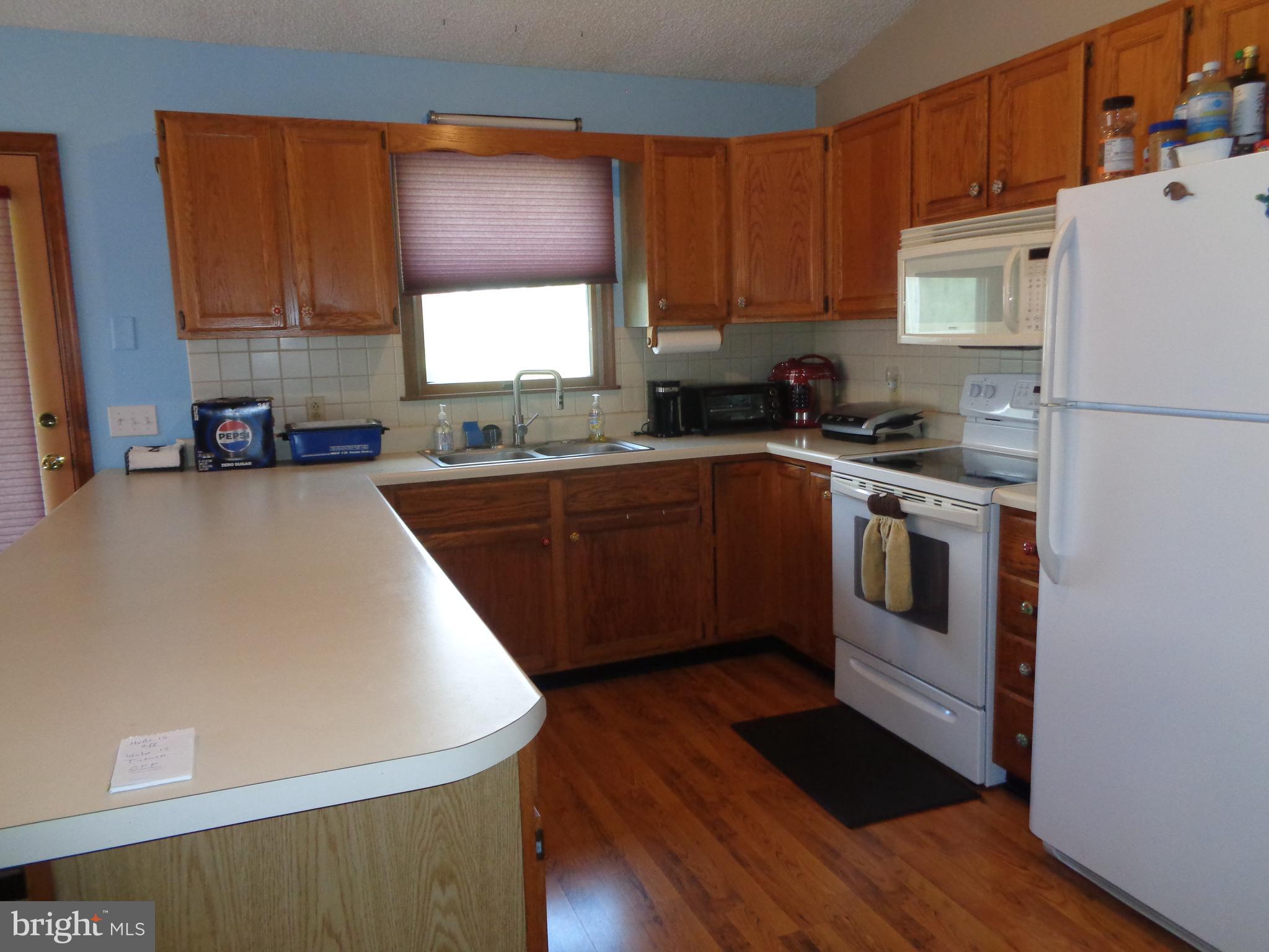 27174 Champ Wharf Road Princess Anne, MD 21853 - Photo 11 of 32 a kitchen with a sink a stove a refrigerator and cabinets
