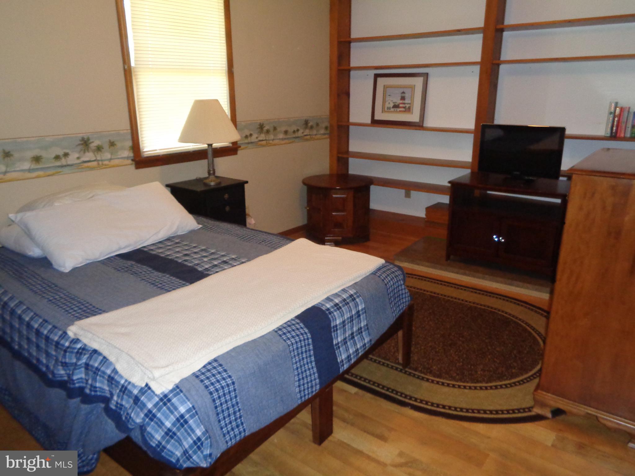 27174 Champ Wharf Road Princess Anne, MD 21853 - Photo 24 of 32 a bed sitting in a bedroom next to a window