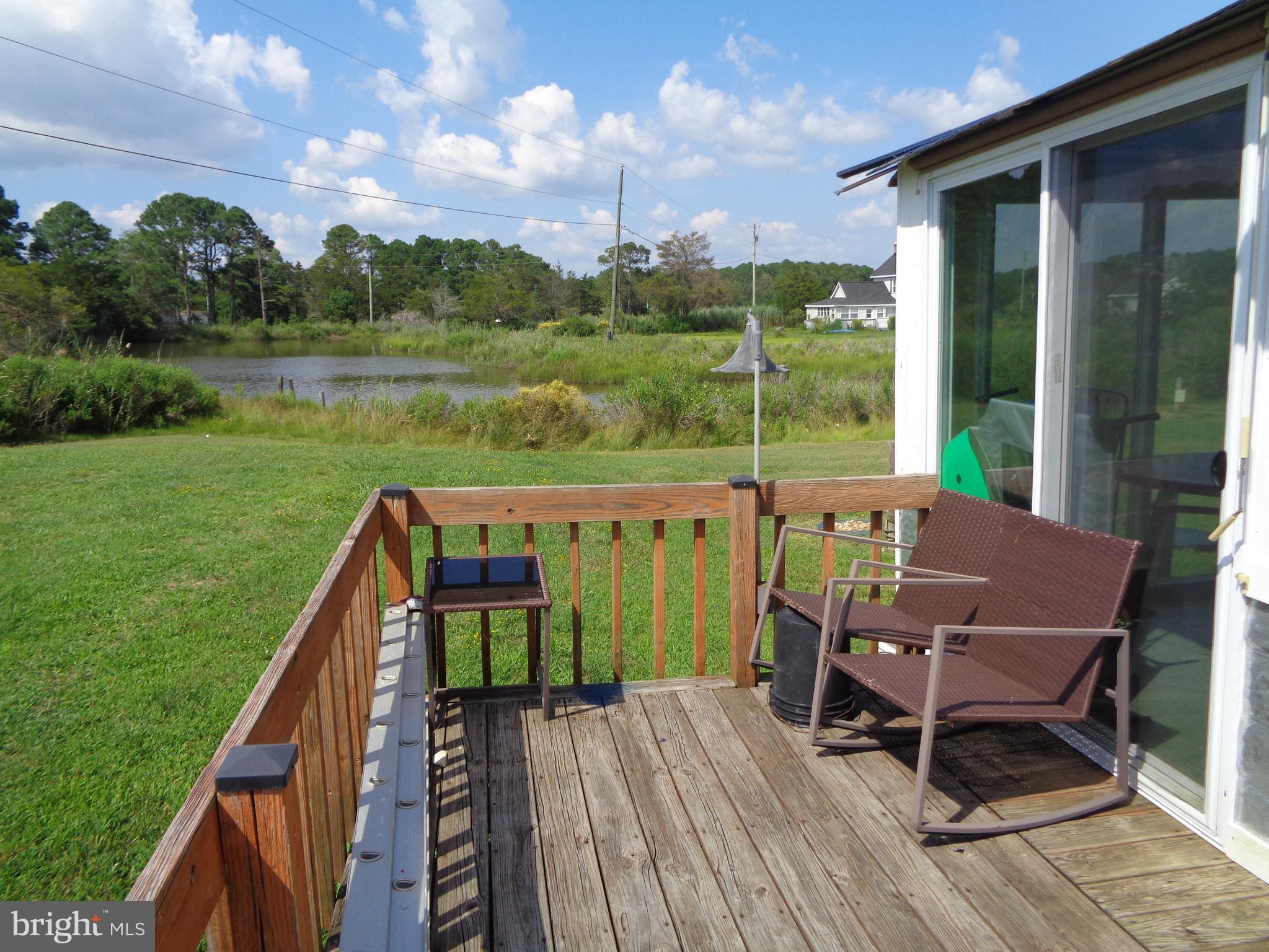 27174 Champ Wharf Road Princess Anne, MD 21853 - Photo 27 of 32 a view of a deck with chairs and a yard