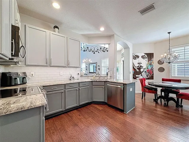 a kitchen with granite countertop appliances cabinets and wooden floor