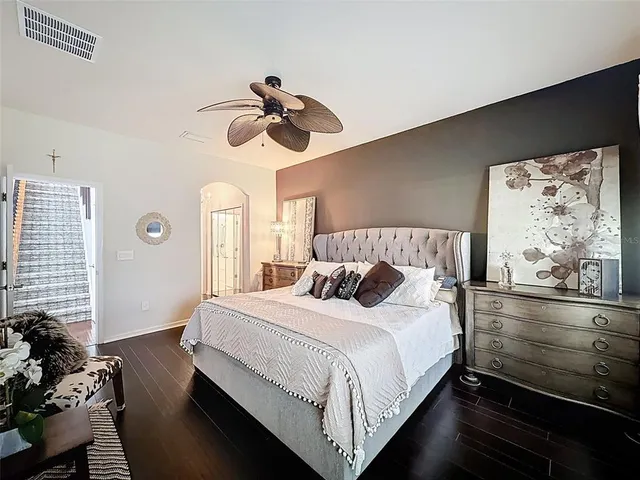 a bedroom with a large bed and a chandelier