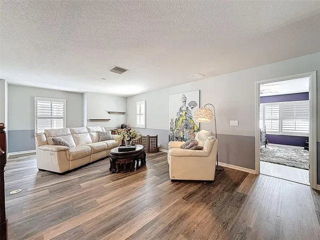 a living room with furniture and wooden floor