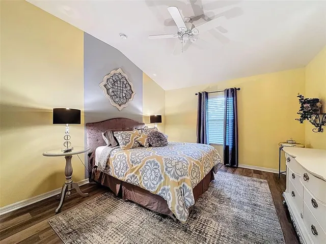 a bedroom with a bed and a table with a flat tv screen