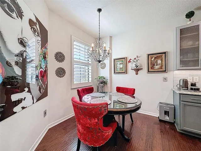 a view of a dining room with furniture a chandelier and wooden floor
